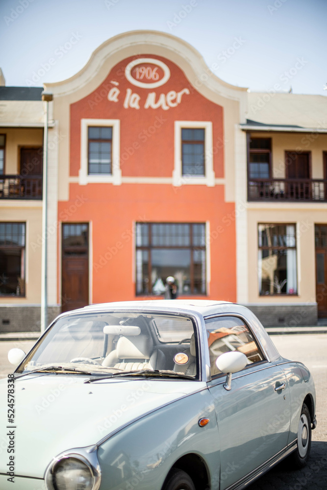 vintage car in front of orange hotel