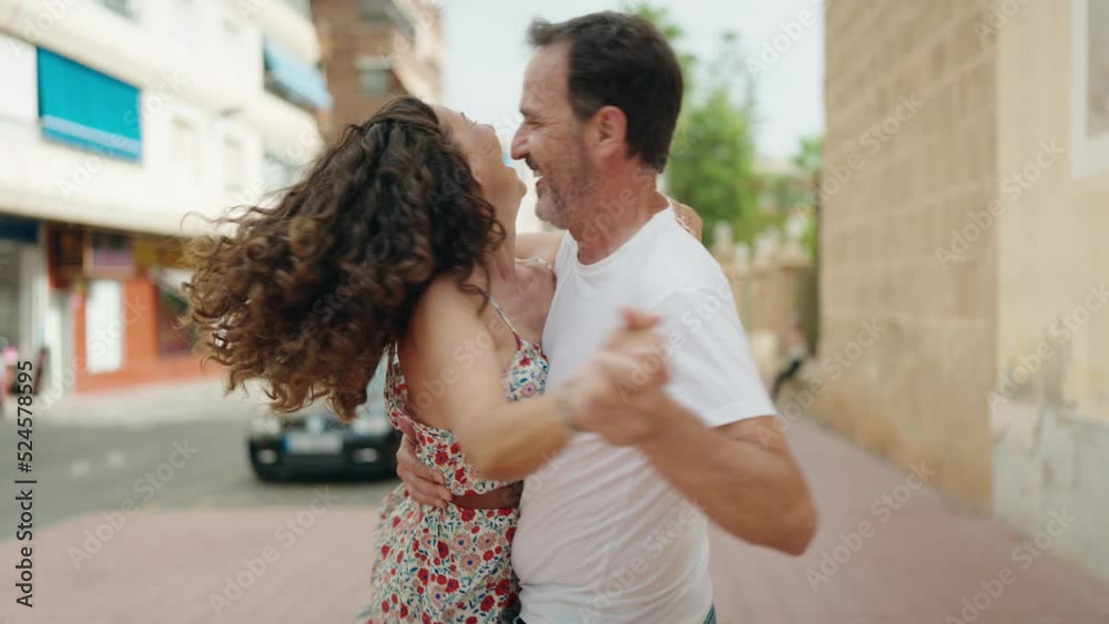 Man and woman couple smiling confident dancing at street