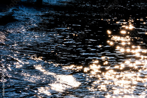 Sunlight glitters on river water surface