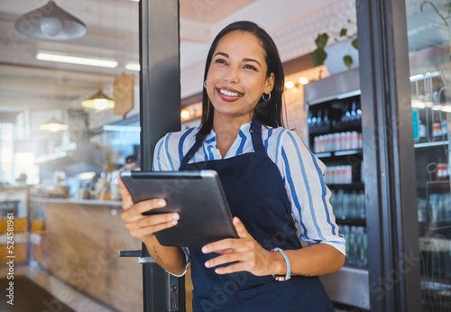 Startup, cafe and business woman in management with smile working on a digital tablet at the store. Manager, coffee shop owner or worker of a small business at work in retail with technology.