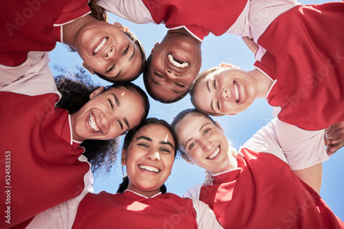 Female soccer team in a huddle smiling in unity and support in a circle. Below portrait of an active and diverse group of women football players or athletes happy and excited for a sports match