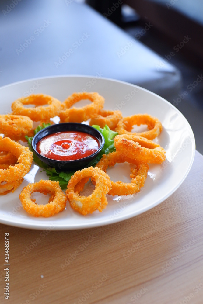 a plate of fried onion rings with tomato sauce 