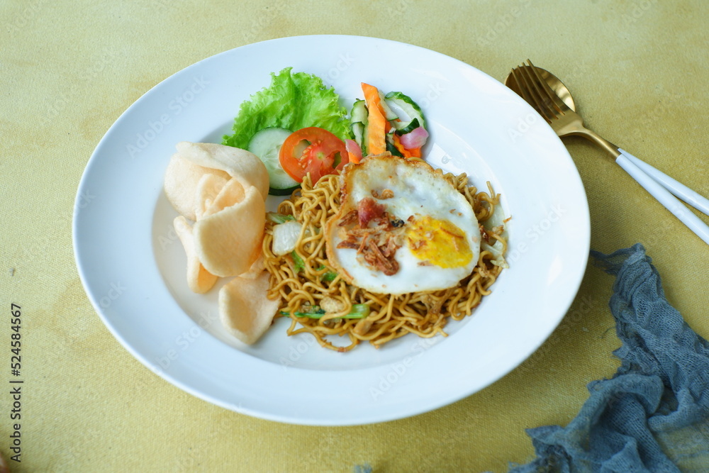 a plate of fried noodles served with vegetables a plate of fried noodles served with vegetables