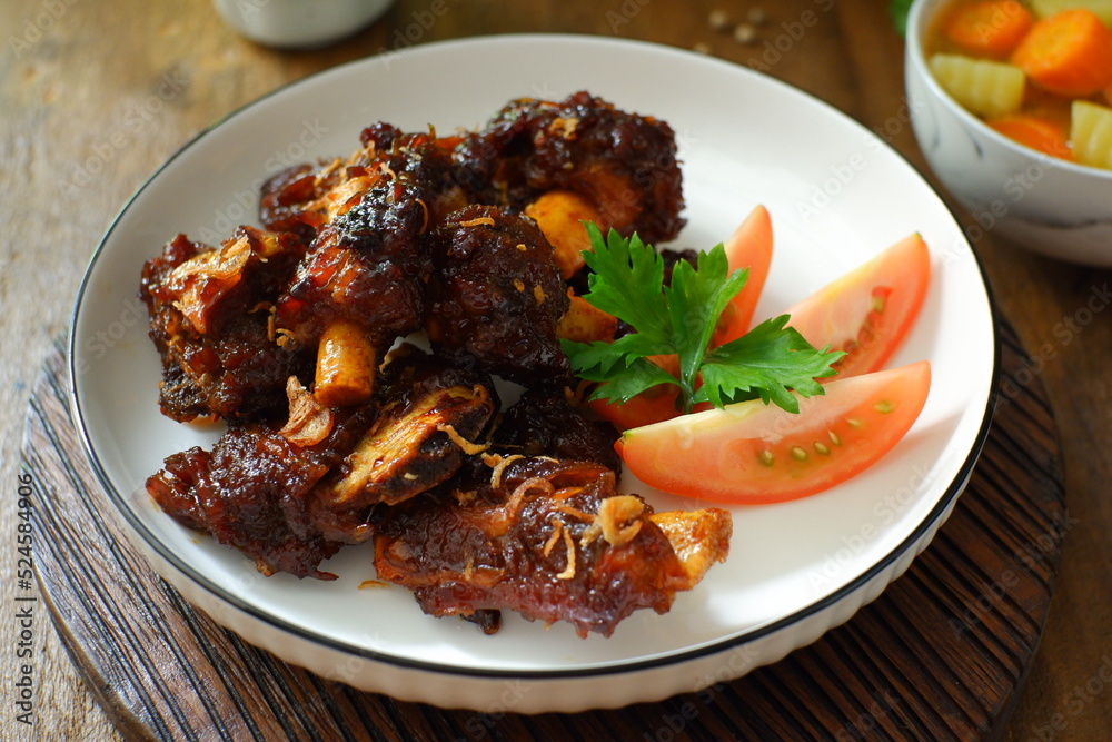 a plate of grilled beef ribs served with vegetables a plate of grilled beef ribs served with vegetables