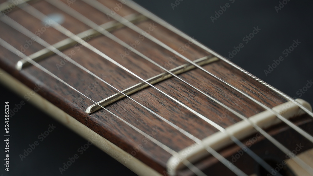 Guitar neck of black electric guitar on dark background Guitar neck of black electric guitar on dark background