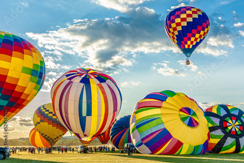 Multiple colorful giant balloons are being blown at the balloons festival