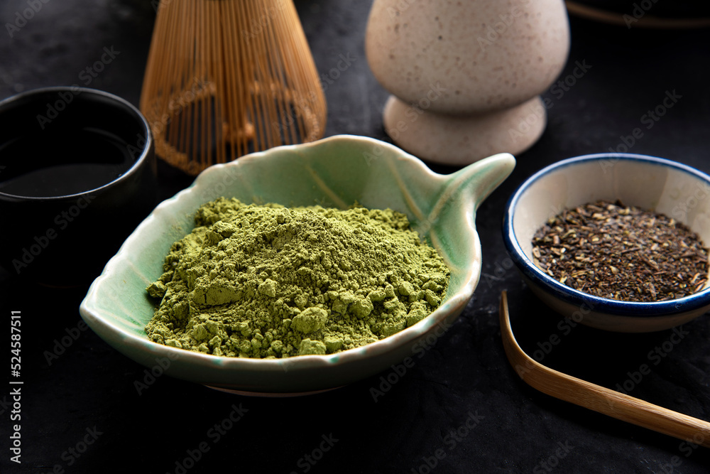 Matcha fine powdered green tea set . Japanese organic matcha green tea powder in bowl with wire whisk on wooden table background. Matcha fine powdered green tea set . Japanese organic matcha green tea powder in bowl with wire whisk on wooden table background.