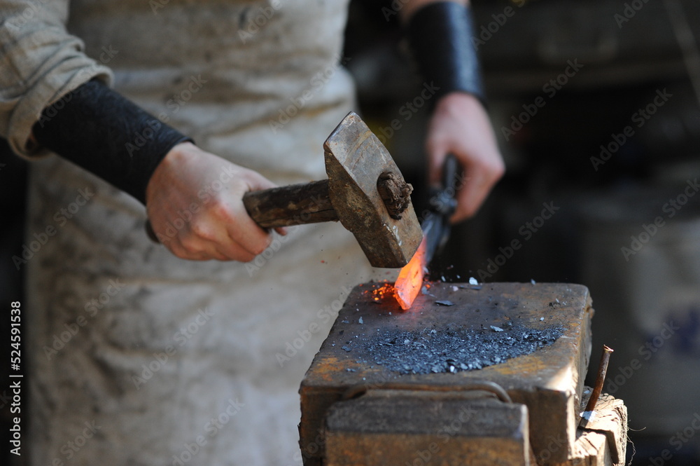 Almaty, Kazakhstan - 09.24.2015 : A blacksmith makes a metal holder for knives and tools in the workshop.