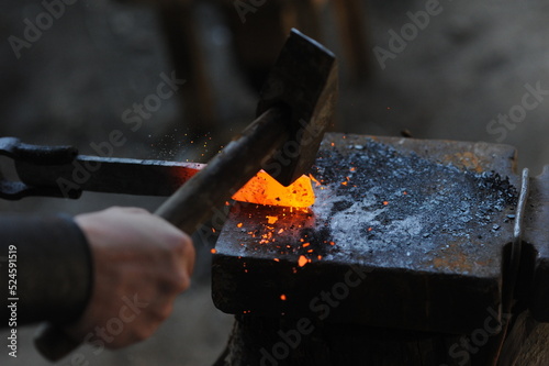 Almaty, Kazakhstan - 09.24.2015 : A blacksmith makes a metal holder for knives and tools in the workshop. photo