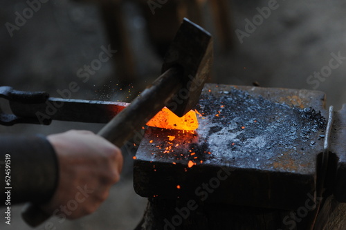 Almaty, Kazakhstan - 09.24.2015 : A blacksmith makes a metal holder for knives and tools in the workshop.