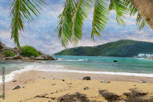 Naiharn Beach in Phuket Thailand  turquoise blue waters  lush green mountains colourful skies. Phuket is a tropical island many palms