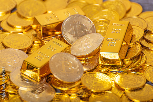 Bitcoin gold coins on a pile of gold coins, gold bars, virtual currency
