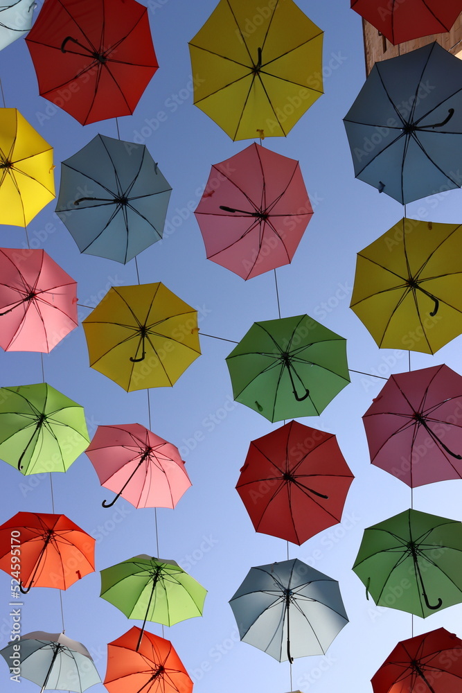 Colored umbrellas on a blue sky