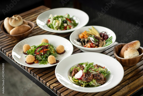 several different fresh salad dishes on restaurant table