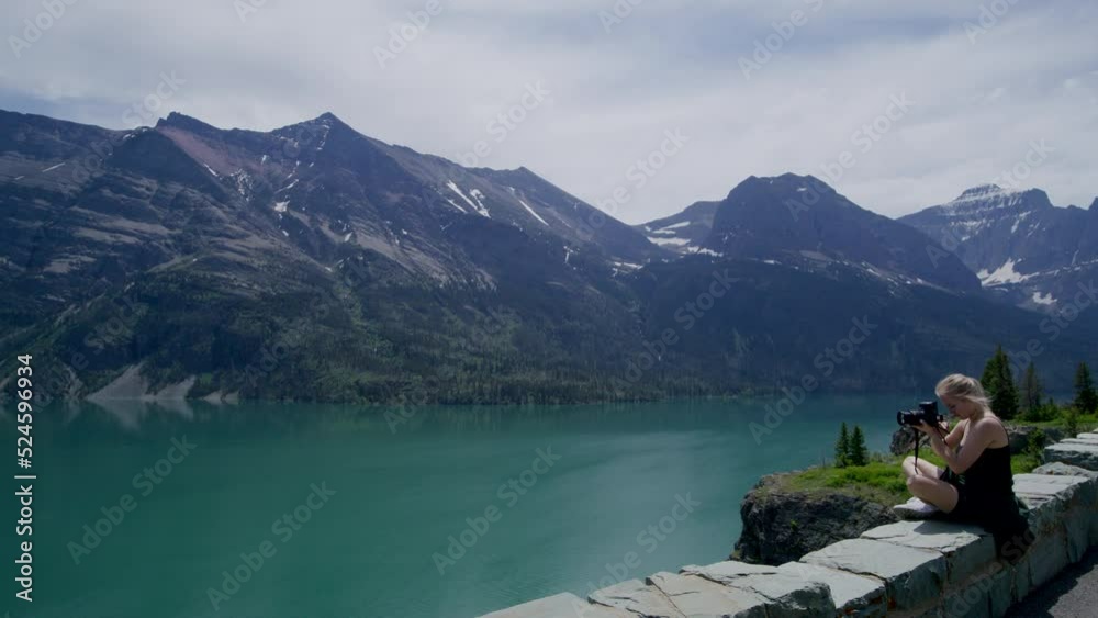Beautiful lake, jugged rocks, covered in fir forest as seen from the shore. Female photographer filming panoramas of pristine wilderness. High quality 4k footage Beautiful lake, jugged rocks, covered in fir forest as seen from the shore. Female photographer filming panoramas of pristine wilderness. High quality 4k footage