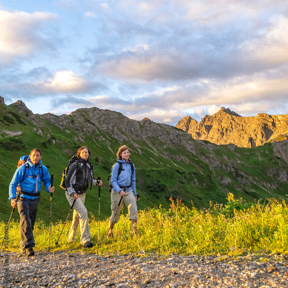 Bergwanderer genießen die Ruhe und die wärmende Morgensonne im Gebirge Bergwanderer genießen die Ruhe und die wärmende Morgensonne im Gebirge