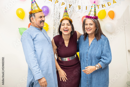 Happy Indian asian old couple celebrate birthday with daughter. elderly retired people and young doing party together.