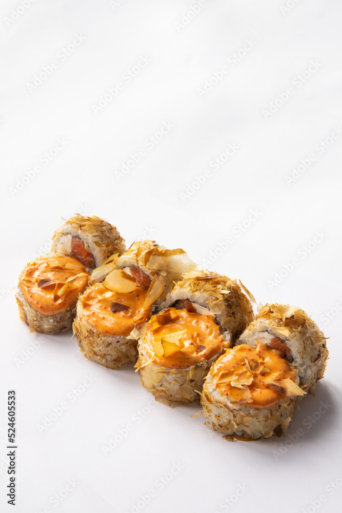 sushi rolls sprinkled with tuna chips and Philadelphia cheese and salmon and sauce
