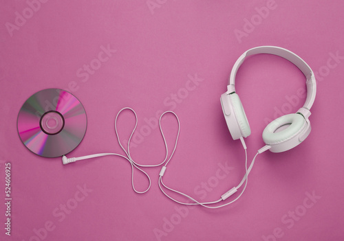 Musical layout. Headphones and cd on pink background. Top view. Flat lay