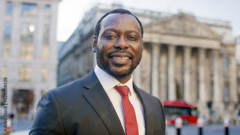Fototapeta premium Portrait of handsome business man in the city looking to camera and smiling 