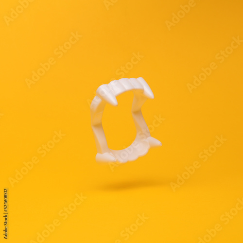 Obraz na plátně Plastic vampire jaw with fangs flying in antigravity on yellow background with shadow