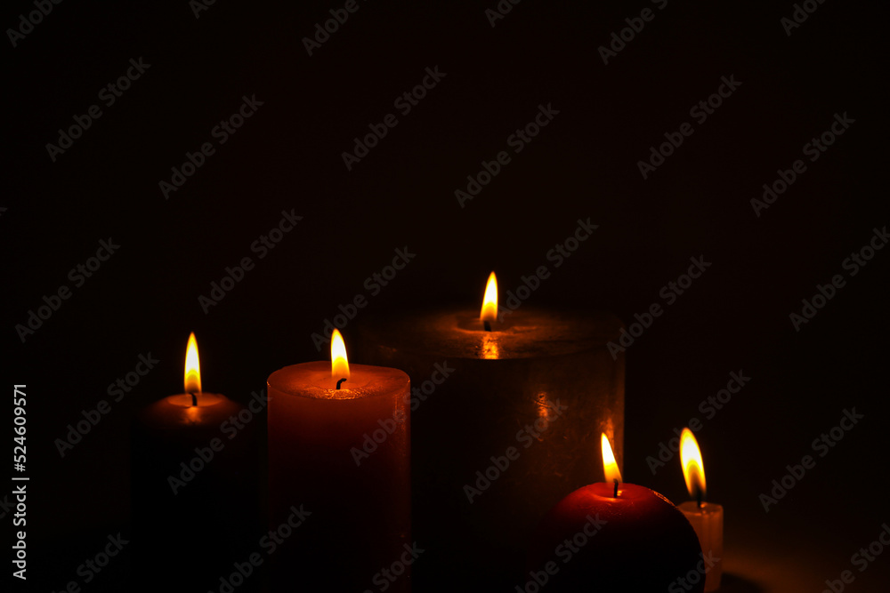 Flaming candles on a dark black background Flaming candles on a dark black background