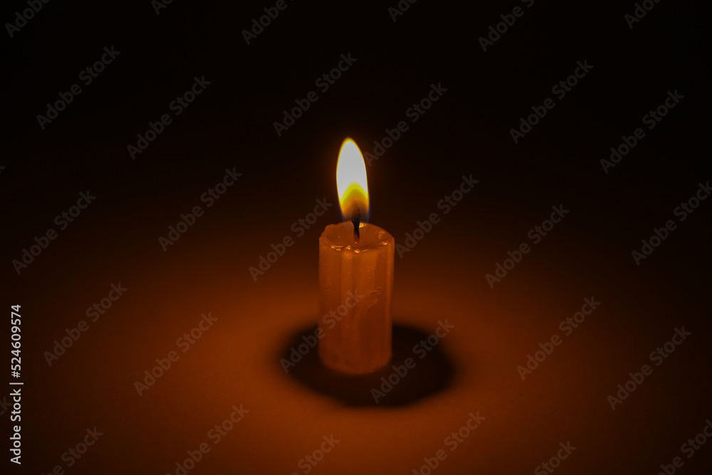 Flaming candle on a dark black background Flaming candle on a dark black background