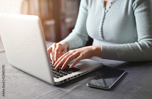 Close-up image of female hands typing on a laptop. Businesswoman text response to client email. Home work concept.