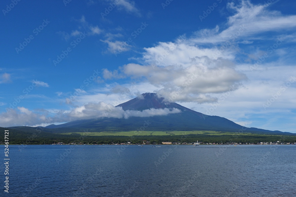 青空の山中湖から雲が一部かかる富士山全体を眺めた写真