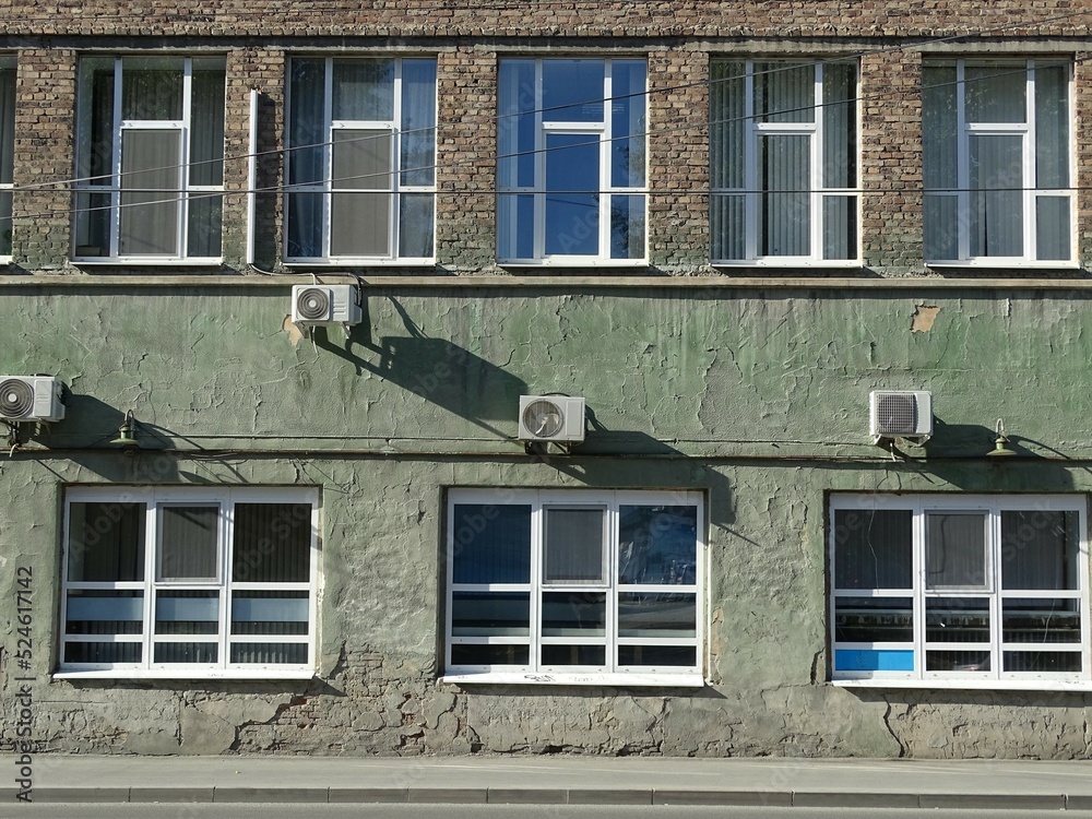 Full-color horizontal photo. Urban landscape. Part of the facade of a historic building. Geometric linear composition with windows.