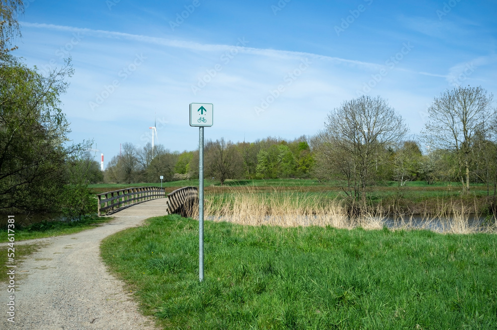 road sign with a route for cyclists in the middle of a park