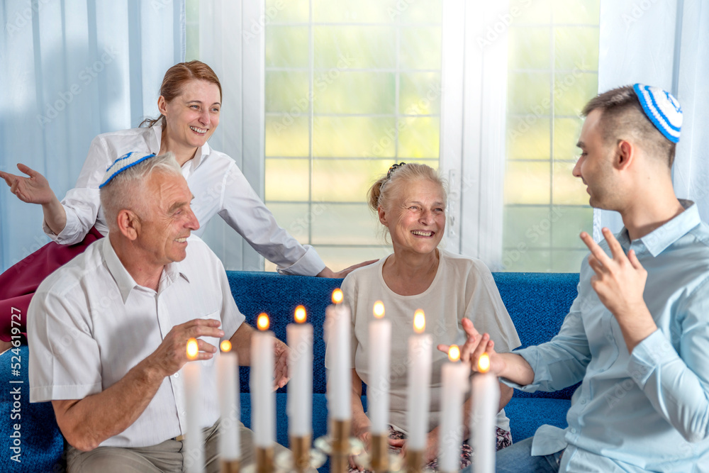 Jewish family celebrates Hanukkah. A senior man and young guy wear