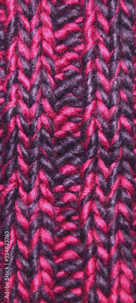 Close-up knitted texture in magenta color palette. Winter texture concept, knitted clothing.