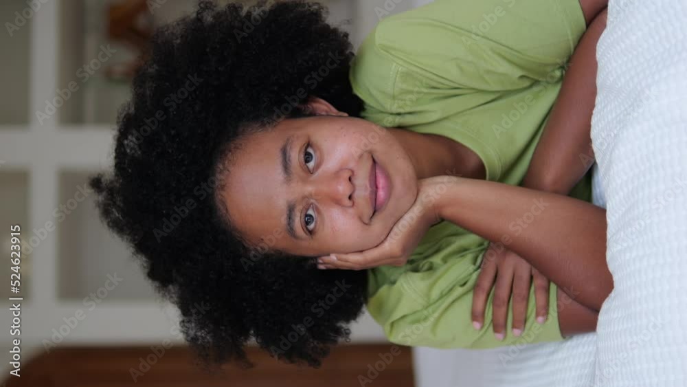 A portrait of an Afro Asian woman with dark skin who lies on the bed ...