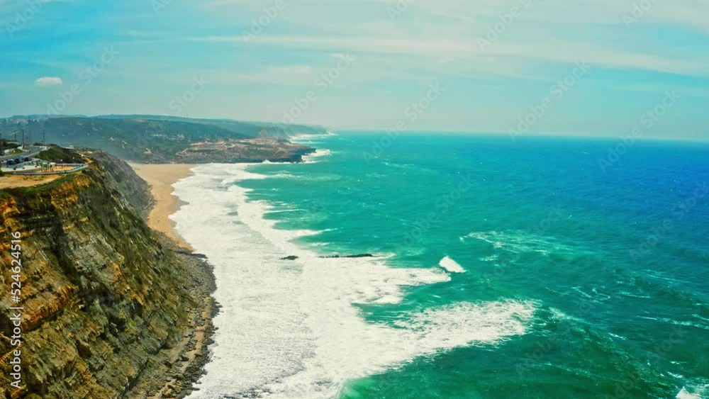 Drone is flying over blue ocean towards sandy beach next to rocky coastline. Aerial view of Atlantic ocean on summer sunny day. Beautiful nature landscape with skyline, seashore, waves and blue sky. Drone is flying over blue ocean towards sandy beach next to rocky coastline. Aerial view of Atlantic ocean on summer sunny day. Beautiful nature landscape with skyline, seashore, waves and blue sky.