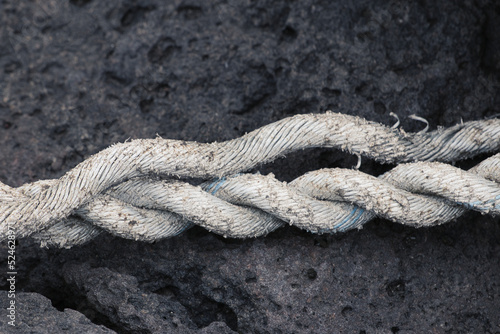 Obraz na plátně Three strands unravelled old white rope on black rock