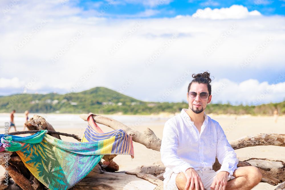 オーストラリアのビーチでヒスパニック系のサングラスをかけた男性と青空