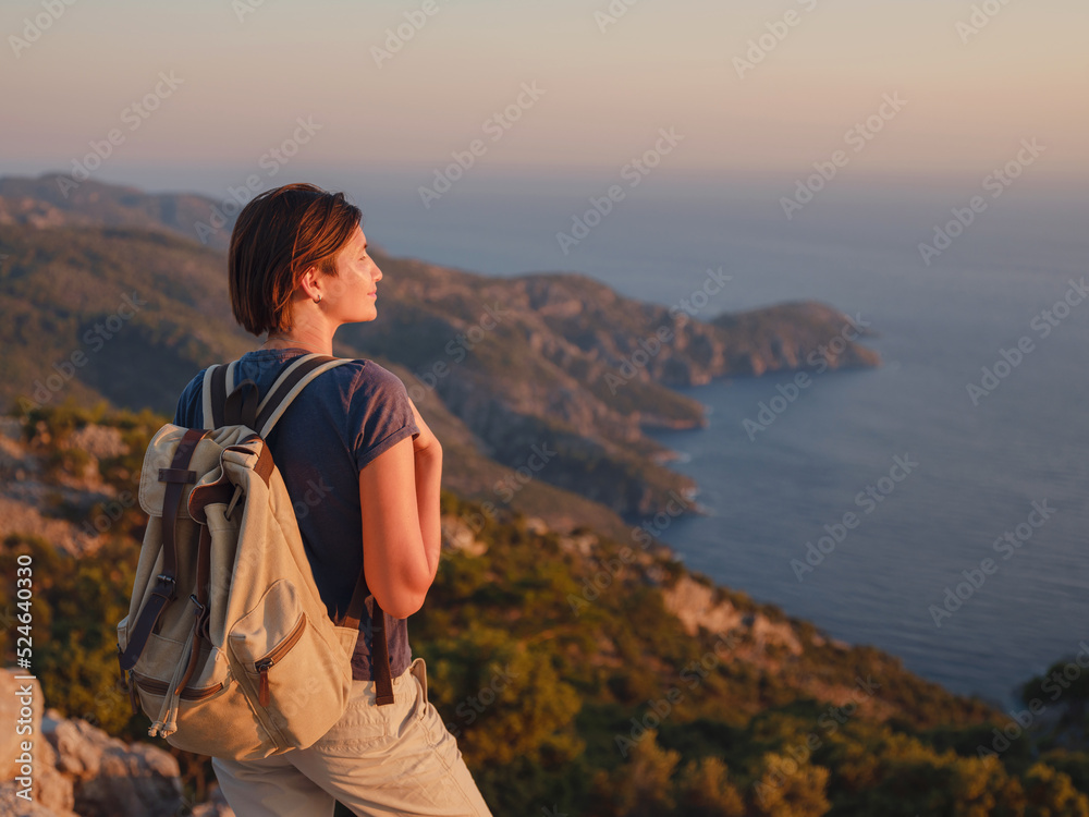 Naklejka premium Travel to Turkey, viewpoint over Dalyan Iztuzu Beach. . Smiling woman taking break on hiking trip looking at view at sunset. Explore natural wonders of Turkey