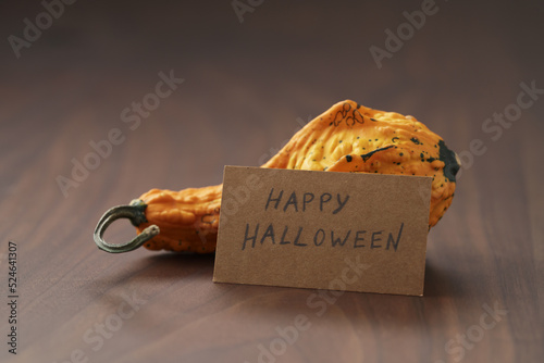 Decorative pear pumpkin on wood table with halloween card photo