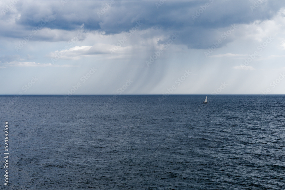 Rain and stormy sky with sailboat on the sea