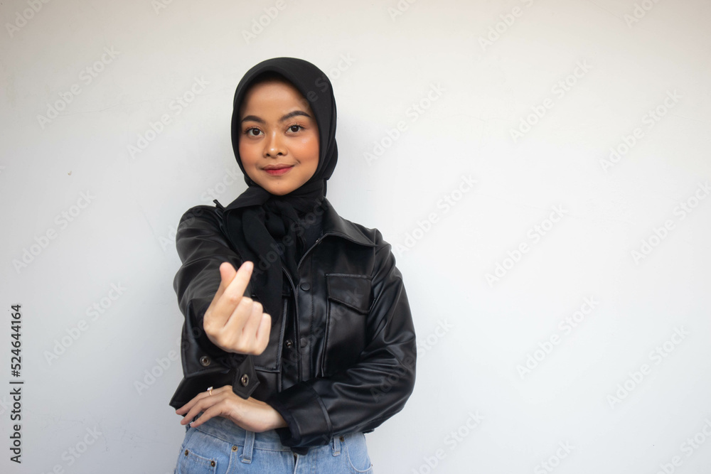Asian beautiful smiling hijab girl showing love korea sign with finger with blurred background isolated white background. Indonesian Women Asian beautiful smiling hijab girl showing love korea sign with finger with blurred background isolated white background. Indonesian Women