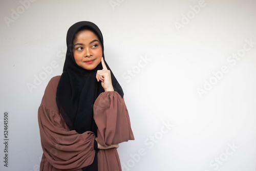 Thinking and smiling Asian woman looking up and touching her cheek by fingers over white background