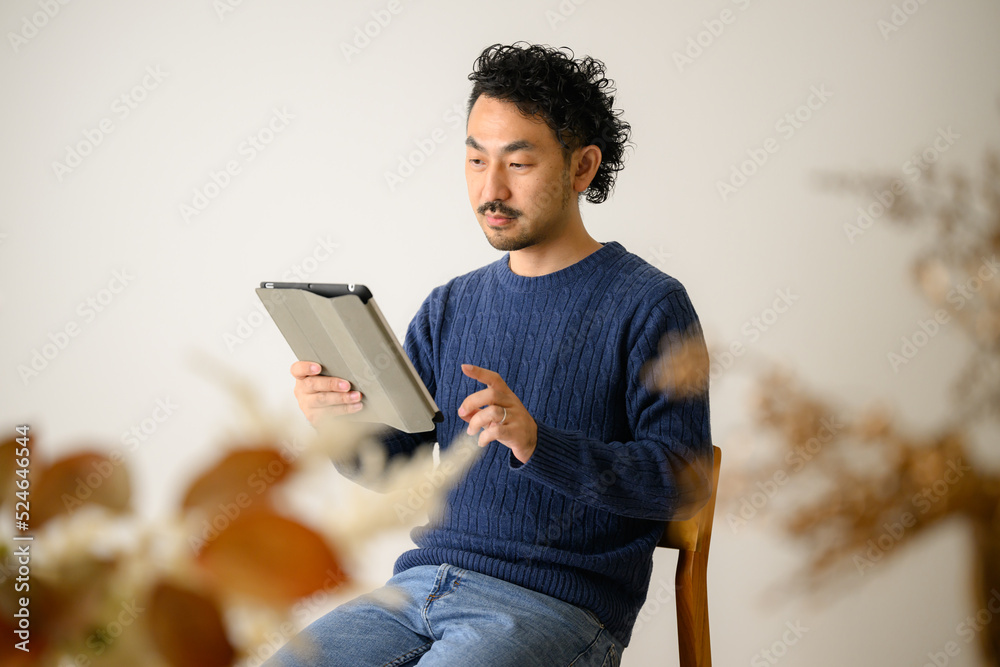 タブレットで仕事をする男性 コピースペースあり 秋冬ニット タブレットで仕事をする男性 コピースペースあり 秋冬ニット