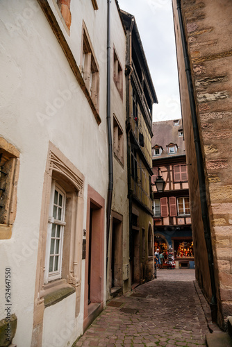 Colmar, Alsace, France, 4 July 2022: town capital of Alsatian wine, narrow picturesque street with medieval colorful houses, Timber framing or post-and-beam construction, romantic city at summer day