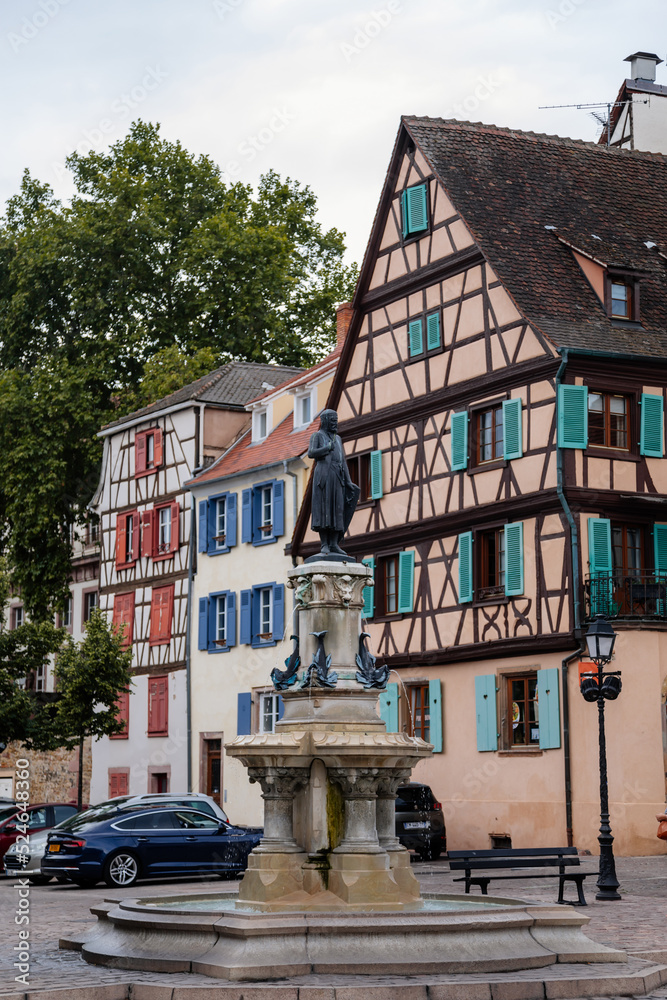 Colmar, Alsace, France, 4 July 2022: town capital of Alsatian wine, narrow picturesque street with medieval colorful houses, Timber framing or post-and-beam construction, Fontaine Roesselmann