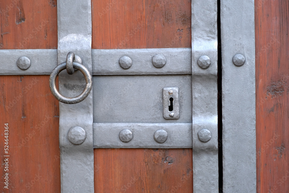Detail of an old ancient castle wooden door with a beautiful iron knock handle. Close up. Detail of an old ancient castle wooden door with a beautiful iron knock handle. Close up.