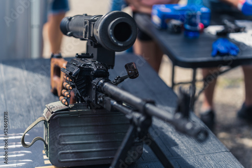 Close up front view of rifle gun scope and barrel standing on table at gunsmith workshop. Horizontal shot. High quality photo