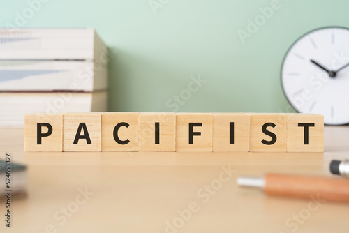 平和主義者のイメージ｜「PACIFIST」と書かれたブロックが置かれたデスク
 photo