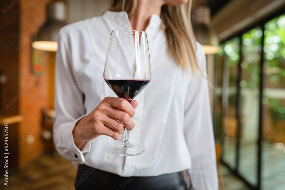 close up on midsection of unknown woman hold glass of red wine close up on midsection of unknown woman hold glass of red wine