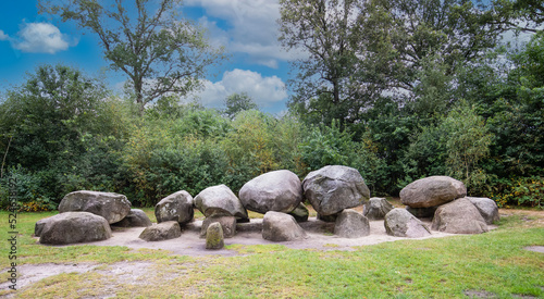 Dolmen D52 in the province of Drenthe in the Netherlands with a background of oak trees.  A dolmen or in Dutch a Hunebed is construction work from the new stone age.